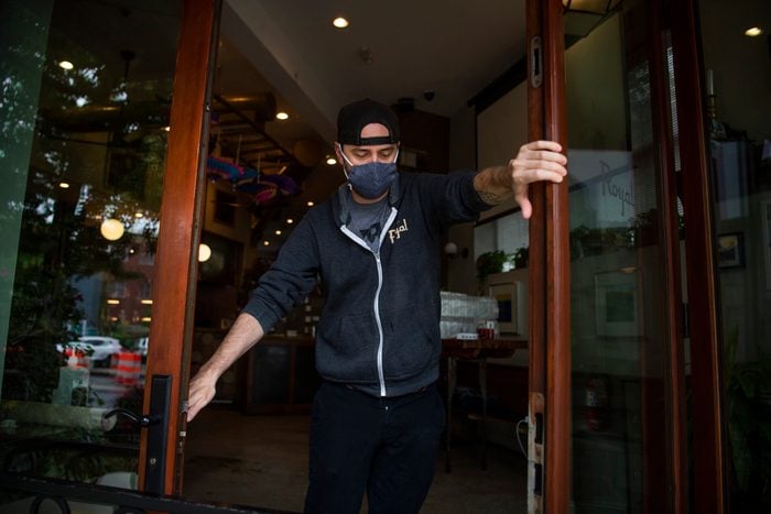 masked man opens restaurant doors