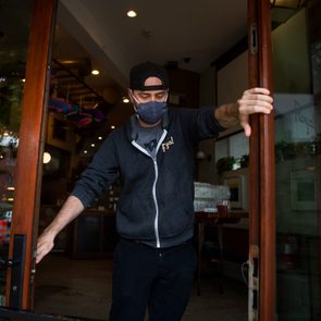 masked man opens restaurant doors