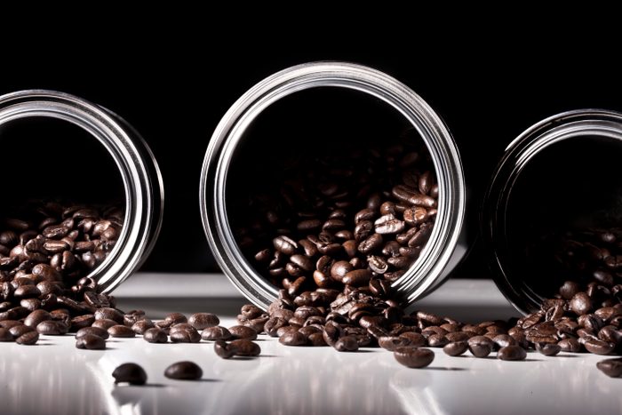 Studio shot of coffee beans spilling from tins