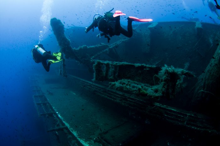 Underwater rear view of divers investigating MS Zenobia shipwreck, Larnaca, Cyprus