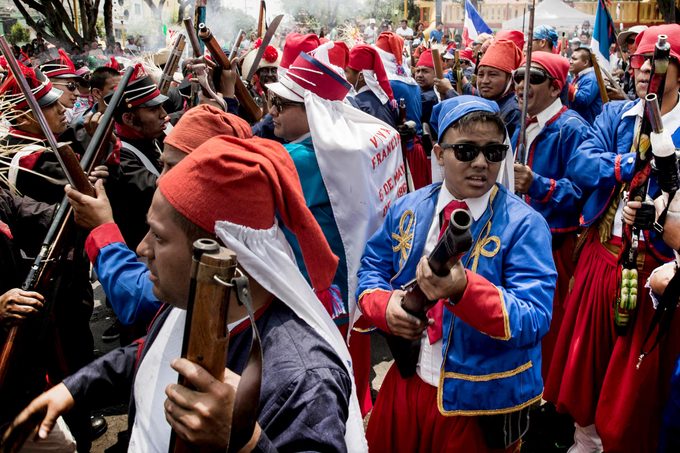people in the streets dressed up to celebrate the Anniversary of "Battle of Puebla" in Mexico