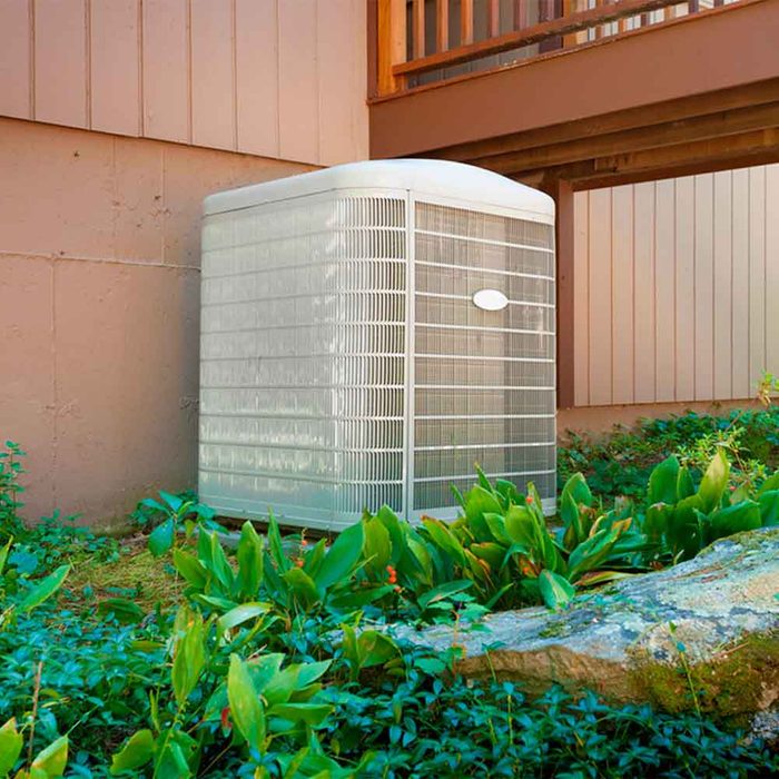 A residential central air conditioning and heating unit sitting outside a home.