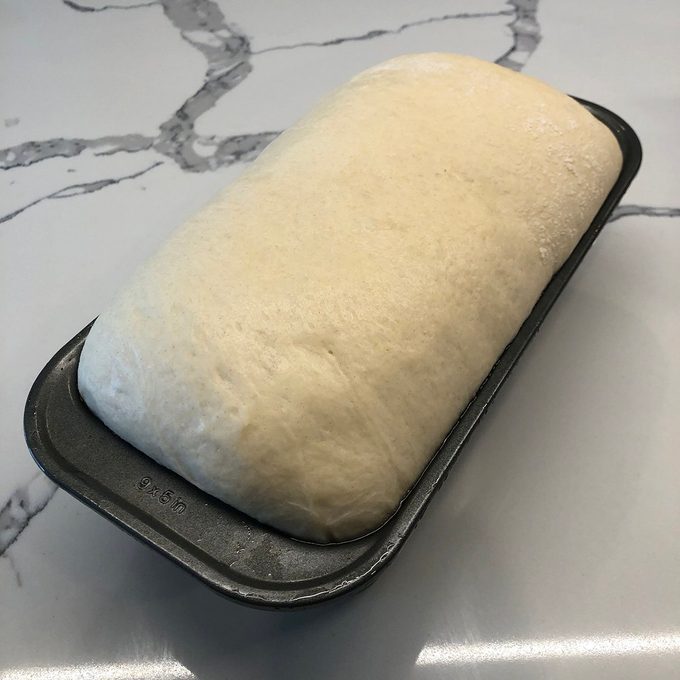 Dough having risen over the edge of the loaf pan