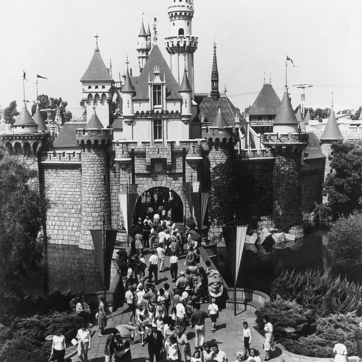 UNITED STATES - JANUARY 01: 1955: Disneyland Welcome : What has become one of the best known landmarks of the wondrous world of Disneyland is this gateway to Sleeping Beauty's Castle. Through its portcullised arch lies Fantasyland, one of the five divisions of Disneyland. Greeting visitors on the castle drawbridge are Snow White and the seven Dwarfs, just a few of the famous Disney characters who inhabit this happy land. Some say that Las Vegas, an hour away by air, is a Disneyland for adults. (Photo by Keystone-France/Gamma-Keystone via Getty Images)