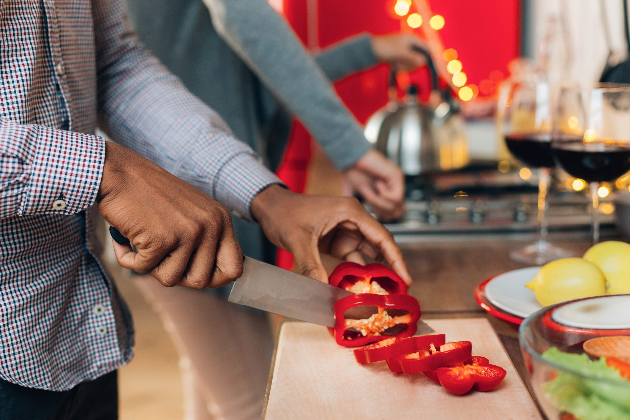 African-american man cutting bell pepper in kitchen