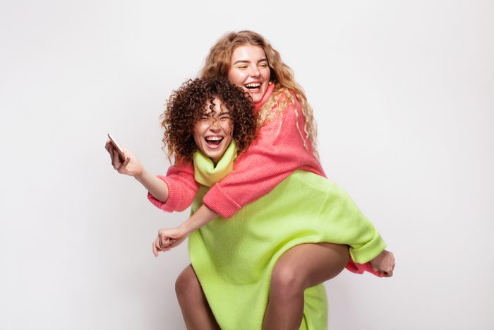 Two joyful beautiful women having fun together