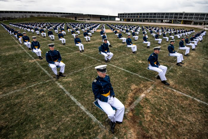 Air Force Academy cadets, spaced eight feet apart, listen to a commencement address