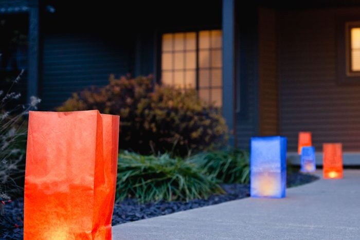 luminaria made from red and blue paper bags line the walkway of a house on the 4th of july