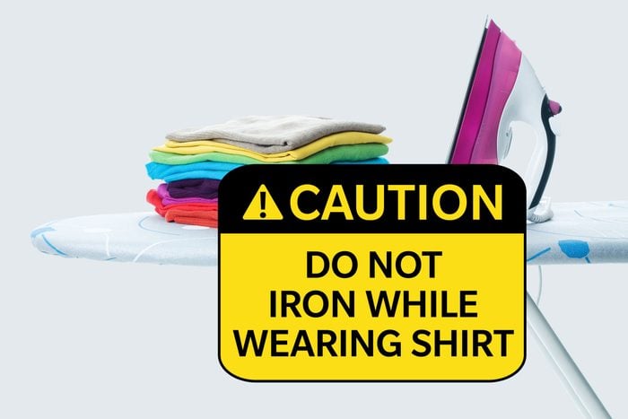 ironing board with shirts and iron. caution: do not iron while wearing shirt