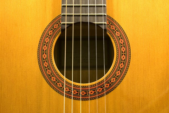 close up of wooden acoustic guitar and strings