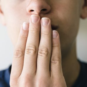 Close-Up Of Man Covering Mouth With Hand