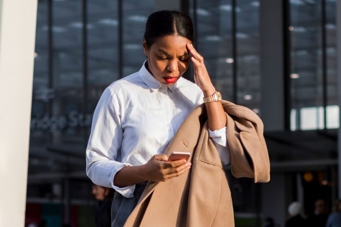 Businesswoman looking at smartphone with panic