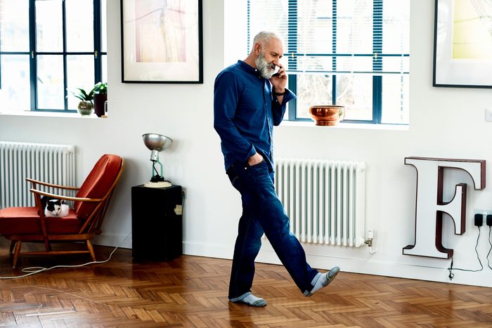 Hipster senior man on cell phone in funky apartment