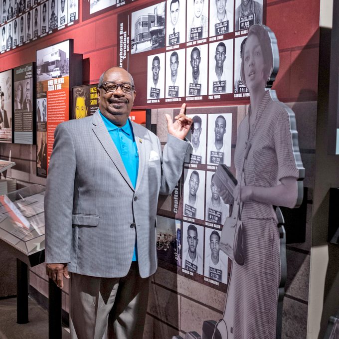 Hezekiah “Heck” Watkins pointing to his mugshot on the wall of the musuem