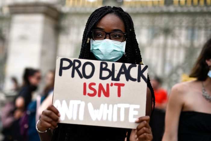 A protester holds a placard reading 'Pro black isn't anti...