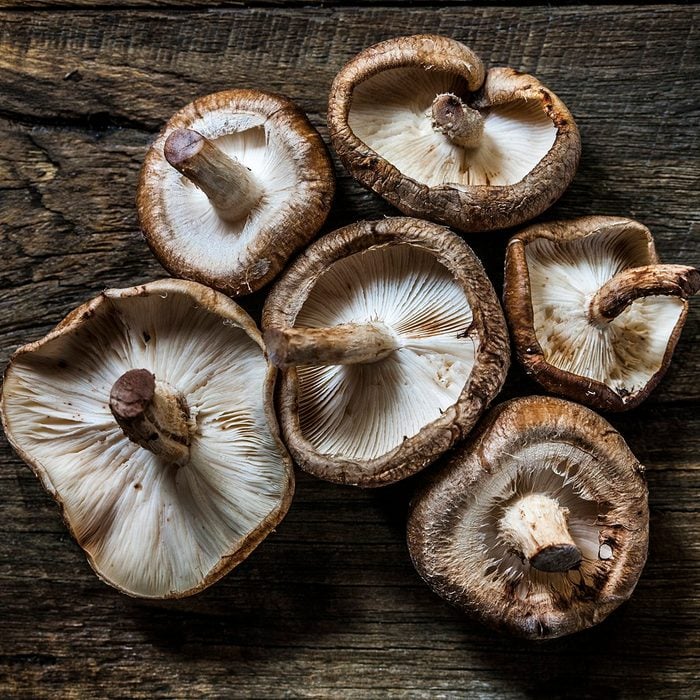 Beautiful Shiitake mushrooms, organically arranged on a rustic wooden background.