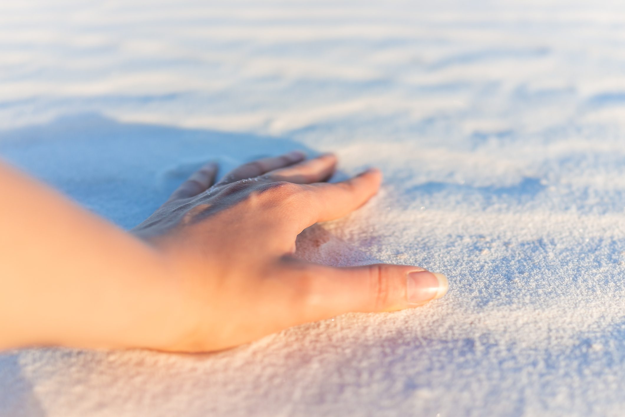 White sands dunes national monument hand closeup of sand texture in New Mexico at sunset