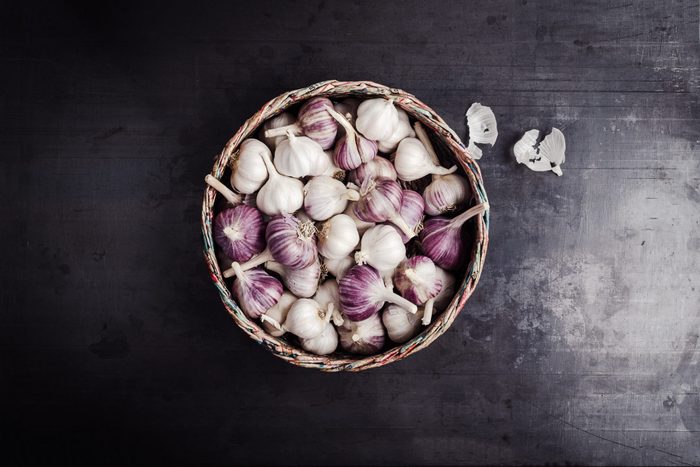 Fresh purple garlic in basket made from newsprint papers