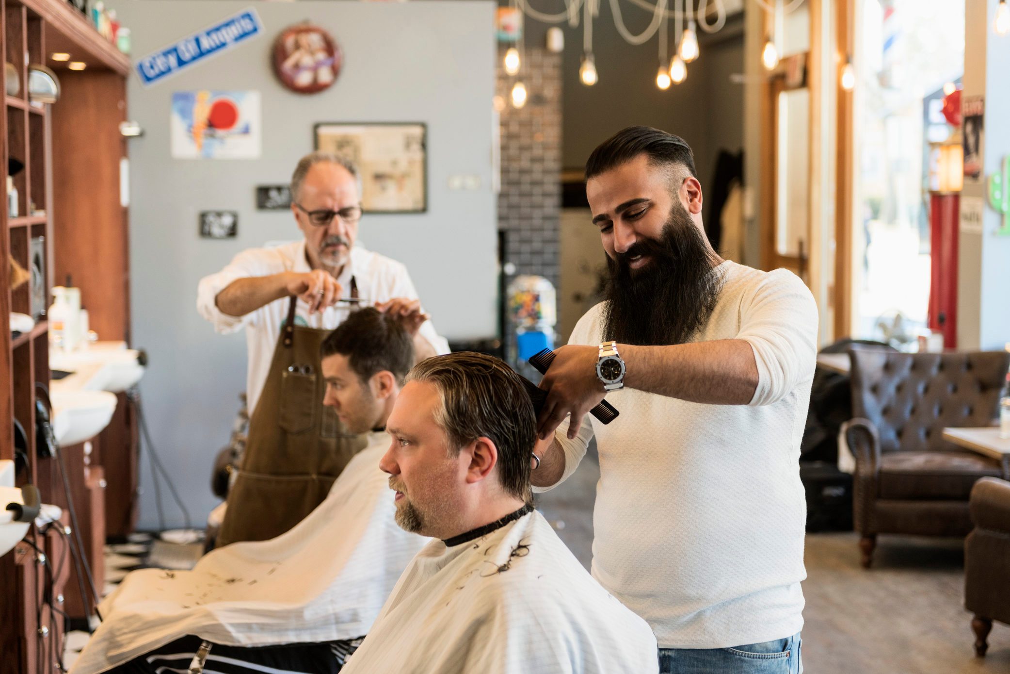 Barbers cutting customer´s hair