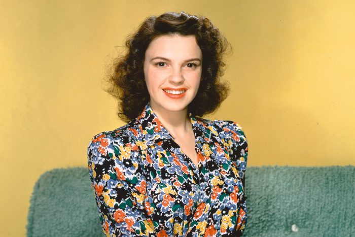 Judy Garland smiling on a couch