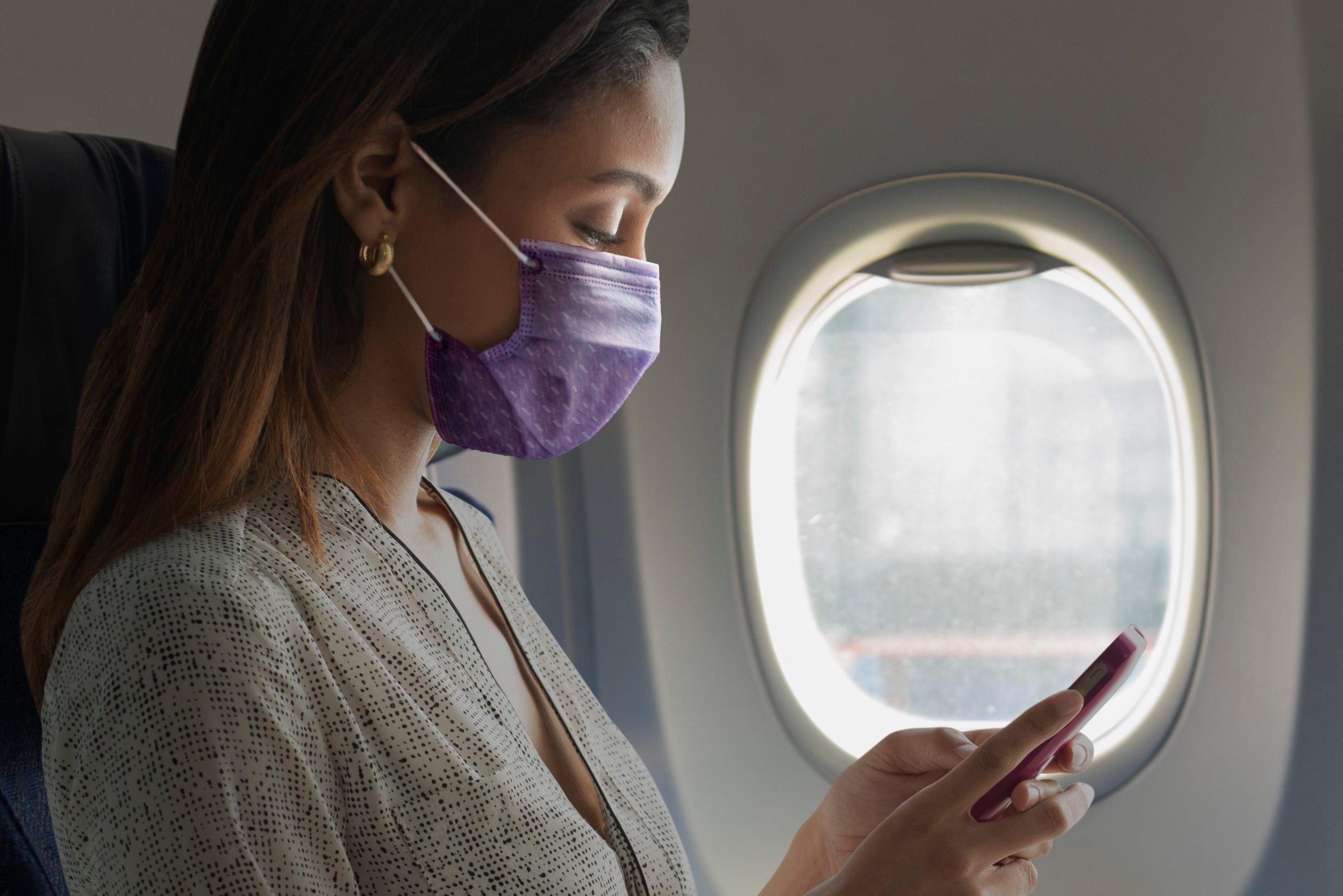 woman wearing mask inside airplane