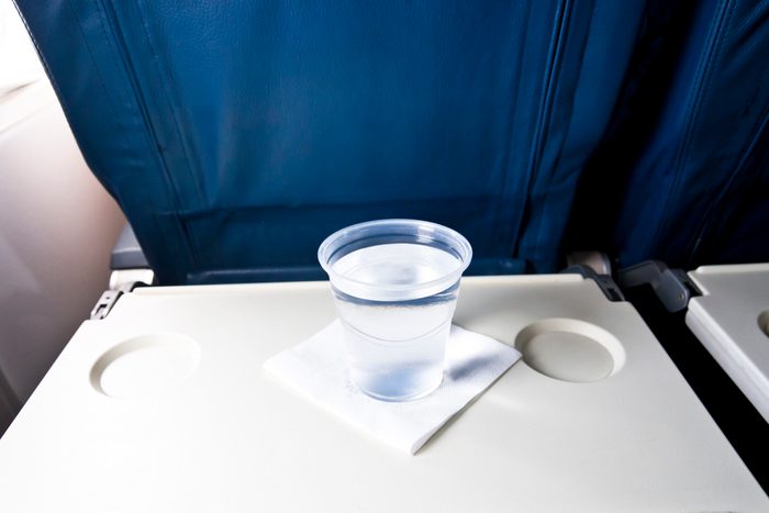 Airplane tray table with a cup of water