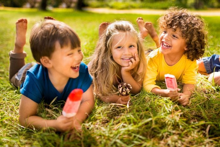Children friends eating ice creams in park