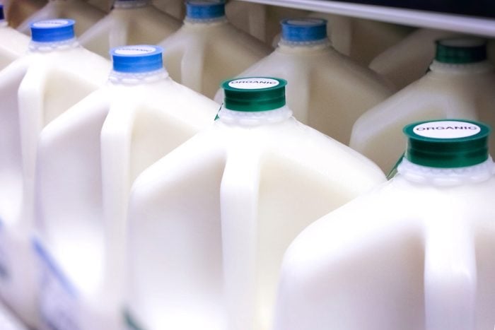 jugs of milk in a store refrigerator