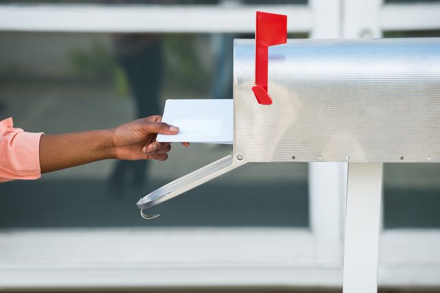 Person Putting Letters In Mailbox