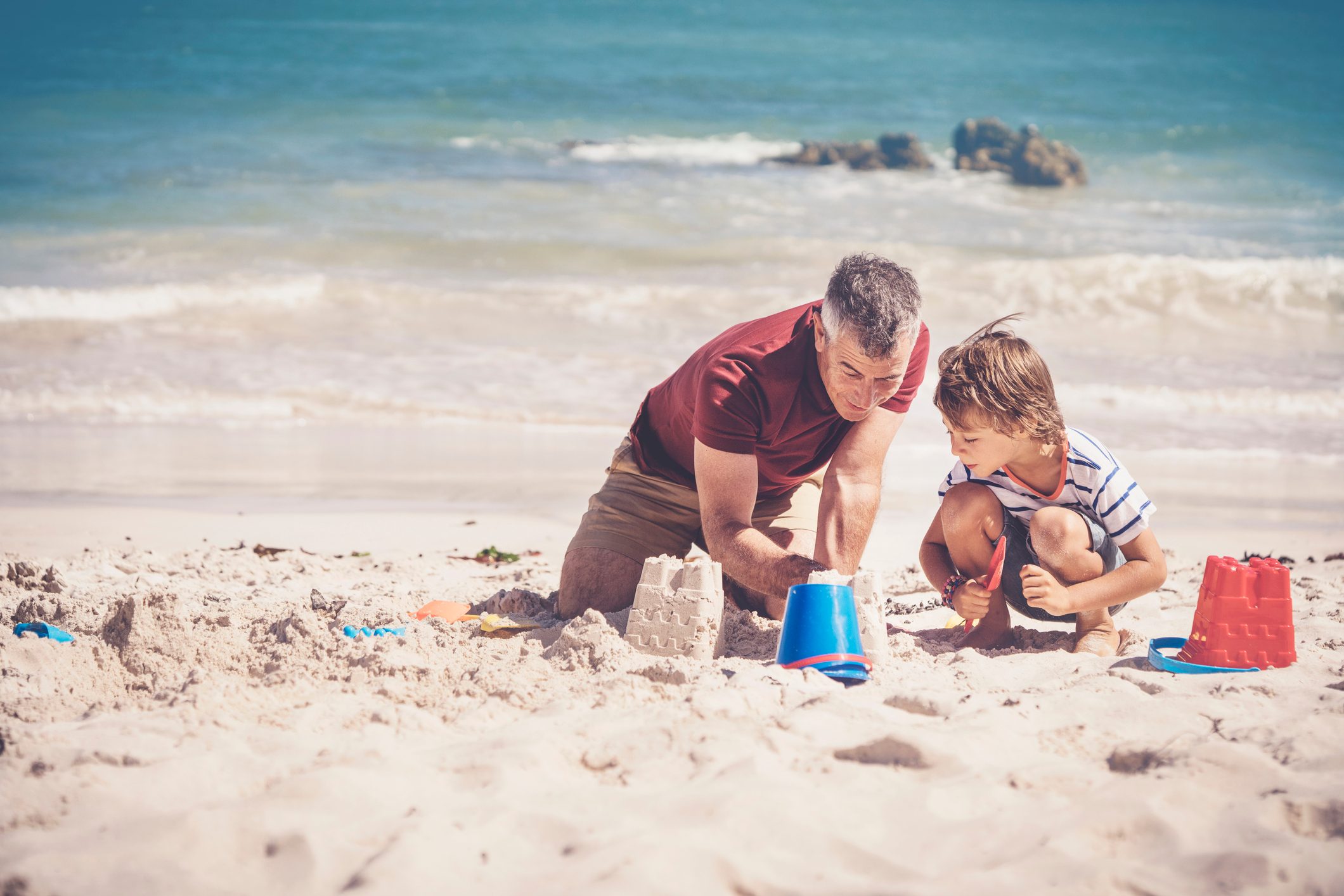 화창한 날에 모래를 만드는 아버지와 소년