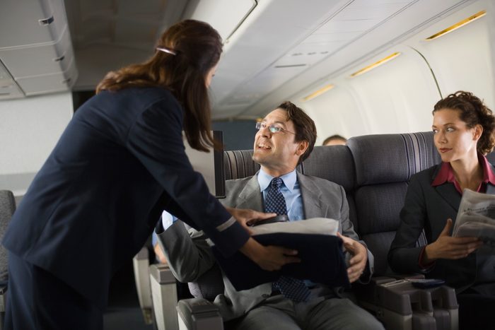 Stewardess handing blanket and pillow to passenger