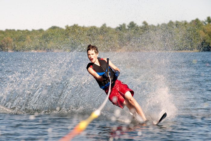 Teenage boy waterskiing on a lake