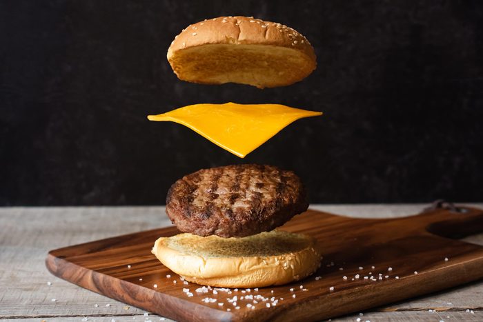 Exploded Hamburger Cheese and Buns on a cutting board against a dark background