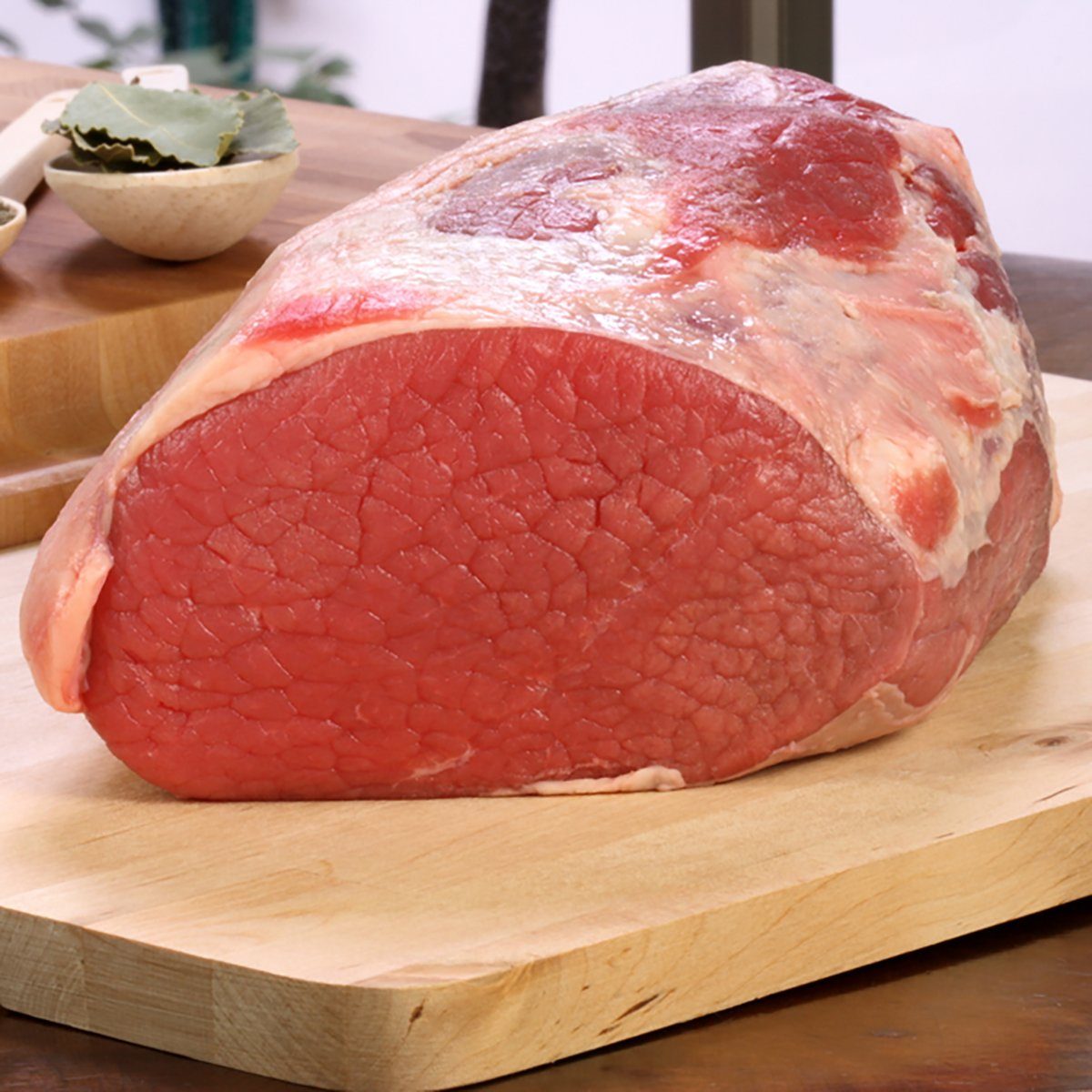 raw fresh and juicy eye of round roast steak or beef with ingredients on background perfect for baking and roasting