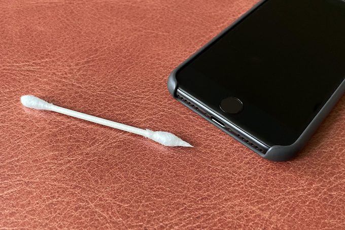 iphone next to q-tip cotton swab with one end of the swab rolled to create a point