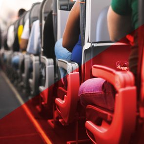view down the aisle of a crowded plane with red overlay on one half