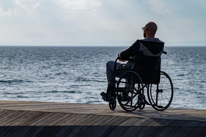 rear view of man in wheelchair at the beach