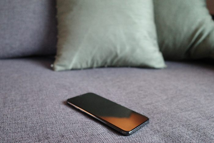 Close-Up Of Smart Phone On Sofa