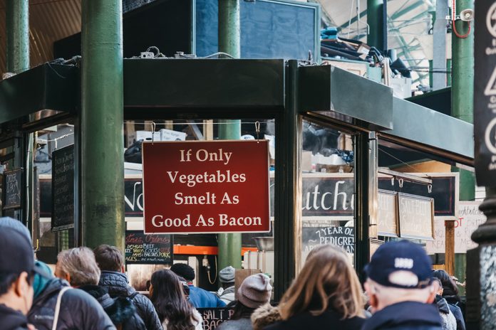 "If only vegetables smelt as good as bacon" sign at Northfield butchery stall in Borough Market, London, UK.