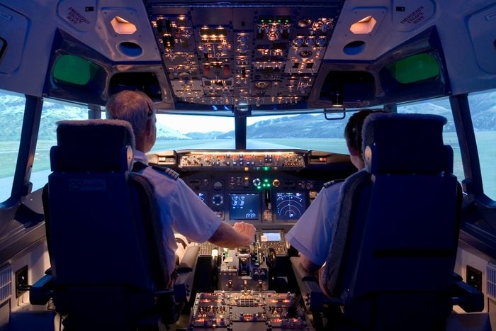 Pilots sitting in flight simulator, rear view