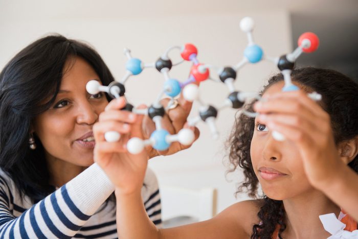 Mother and daughter examining molecular model