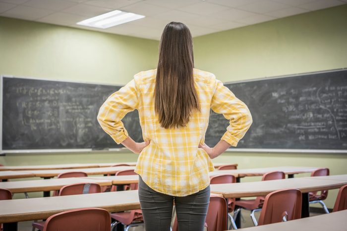 Caucasian woman standing with hands on hips in classroom