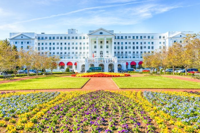Greenbrier Hotel exterior entrance with landscaped flowers, cars, in West Virginia