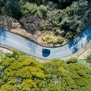 Aerial view of road amidst trees in forest.