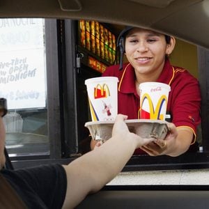 REDWOOD CITY, CA - JULY 29: Josephine Hernandez hands a tray of drinks to a drive thru customer at a McDonald's restaurant July 29, 2003 in Redwood City, California. McDonald's Corporation today reported record second quarter and first half U.S. sales spurred by enthusiasm for its new food offerings and improvement in food taste and service initiatives. Despite the significantly stronger U.S. sales, McDonald?s global profits fell 5 percent as sales in its restaurants in Europe and Asia remained flat.(Photo by Justin Sullivan/Getty Images)