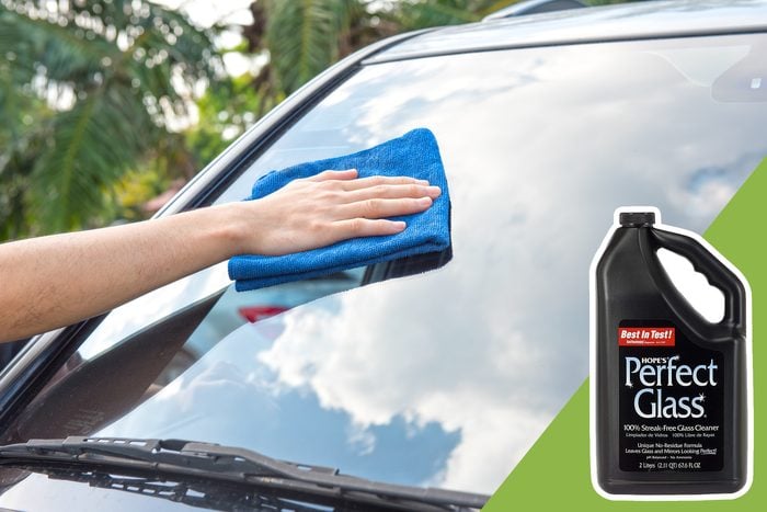cleaning windshield of car with inset of glass cleaner