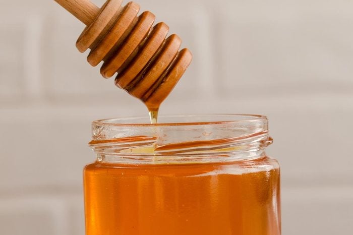 Polyfloral Honey Flows From A Wooden Honey Spoon