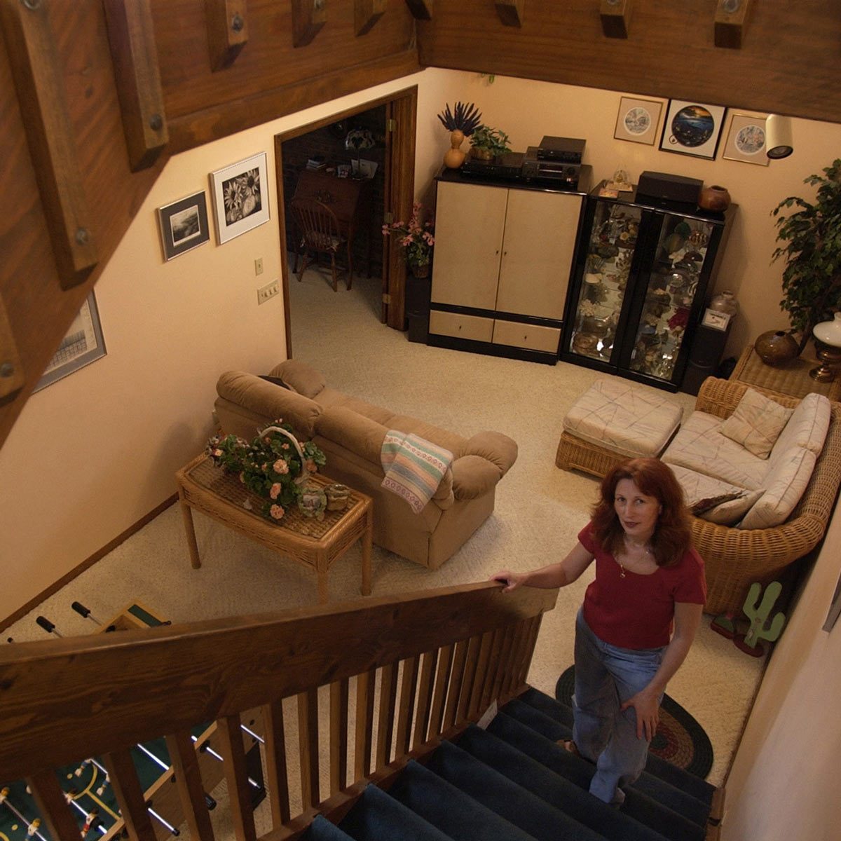 woman standing on a staircase into an underground living room