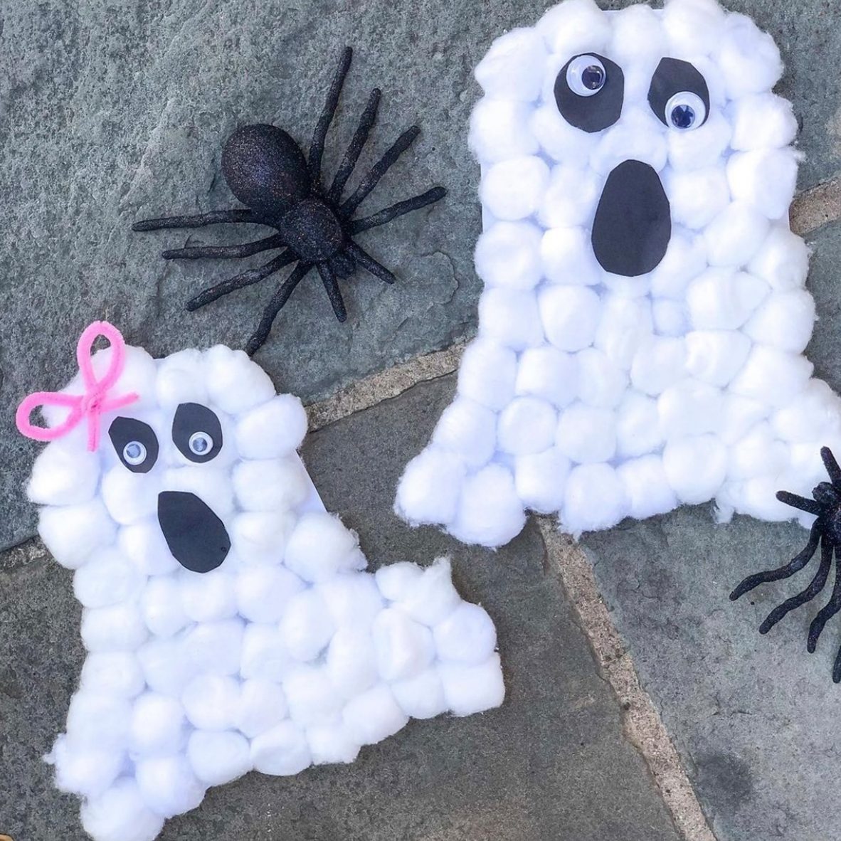 Two small white ghosts crafts, felt sheets, scissors, thread, needle on  lilac wooden background. Hand Halloween decor idea for kids. Halloween  sewing craft Photos