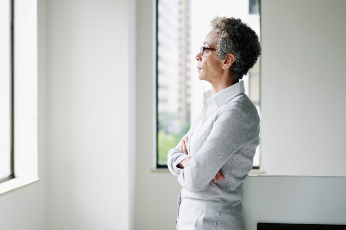 Mature businesswoman in office looking out window